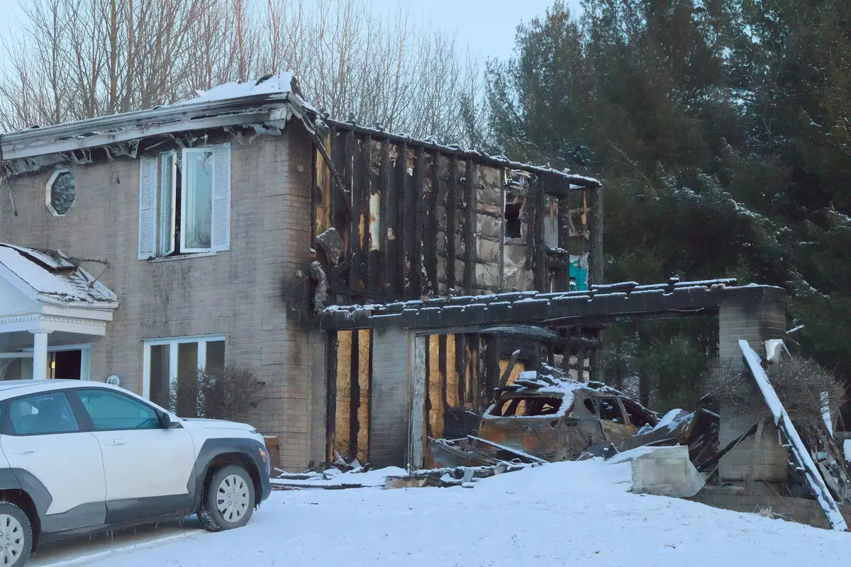 A two story house with fire damage to its upper floor, snow on the ground